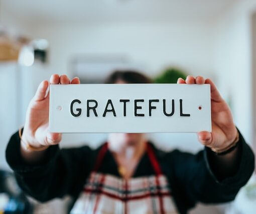Woman holding "grateful" sign